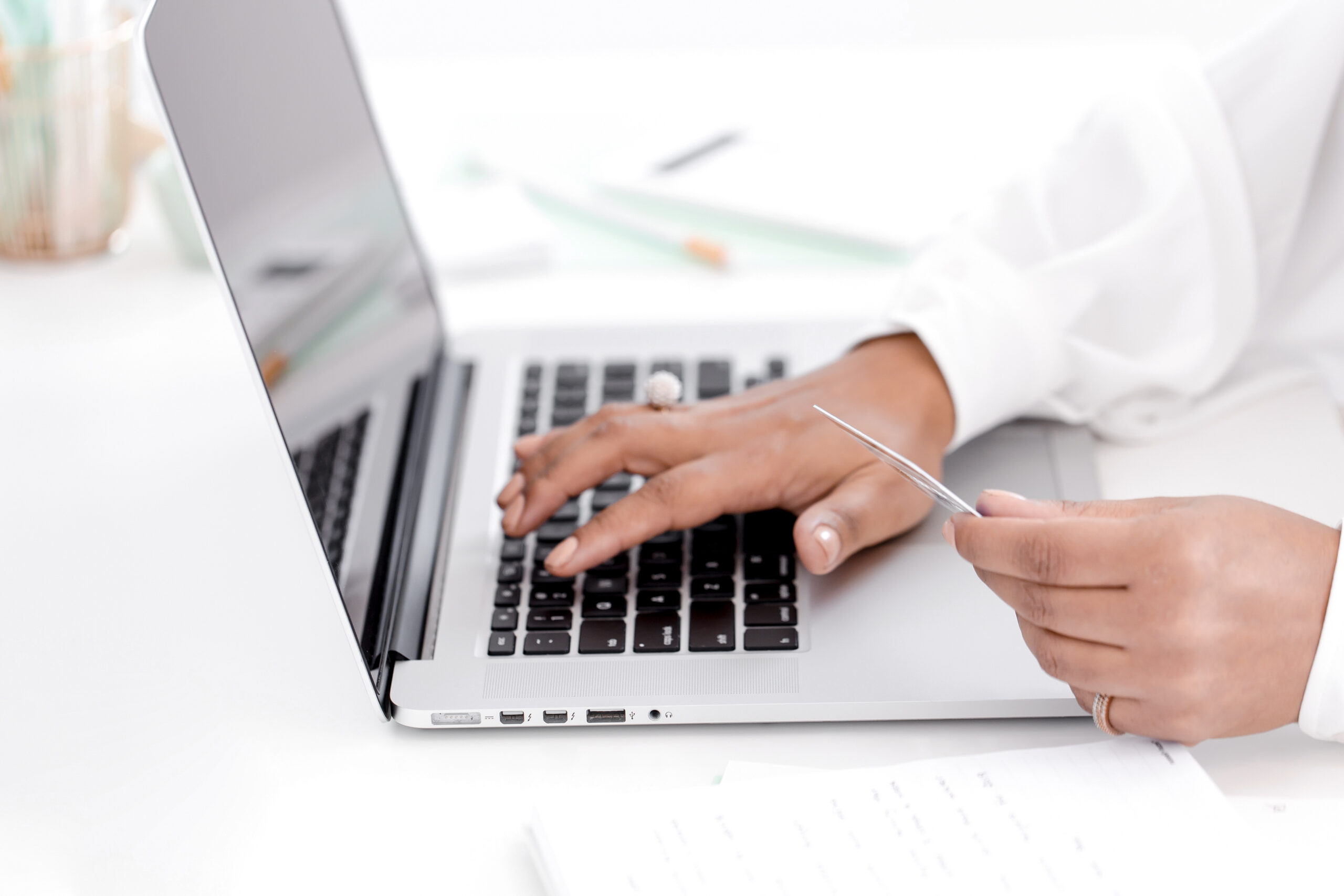 A business owner reviewing financial reports on a laptop, analyzing transaction data for seamless payment processing and financial clarity.