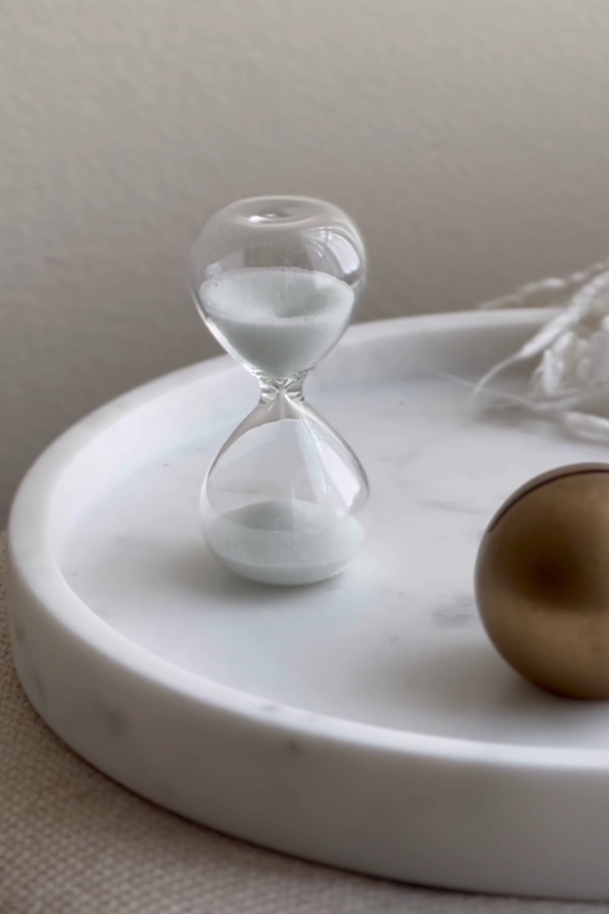 A classic hourglass with sand flowing from the top chamber to the bottom, symbolizing the importance of time tracking and efficient time management in business.